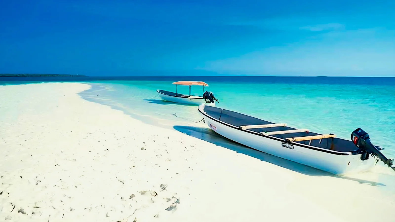 Boats beside a white sandbank on a Pungume Island trip