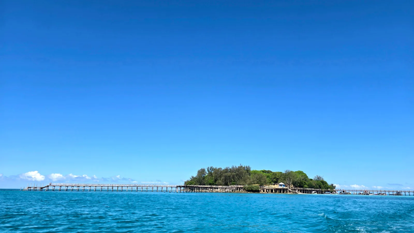 Prison Island and its wooden jetty across turquoise water